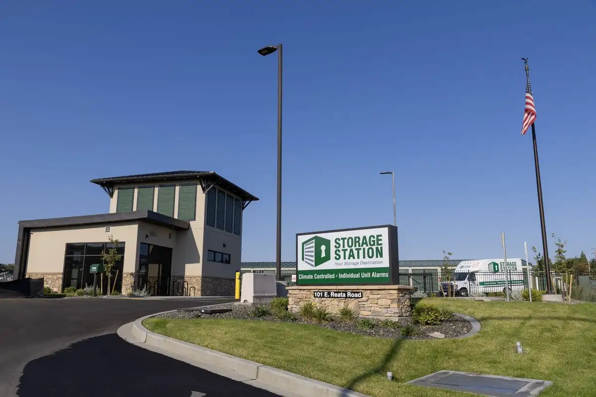 Storage Station entrance with monument sign and flagpole on a clear day