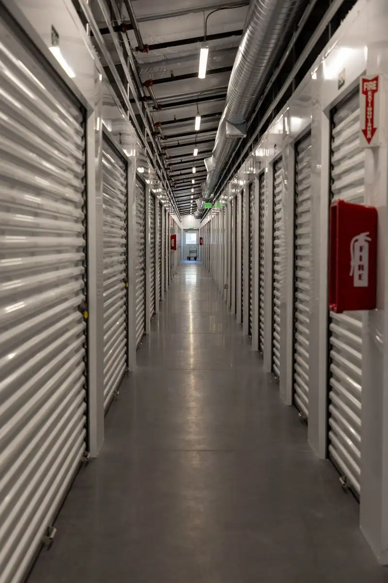 Wide interior hallway with bright white roll-up doors stretching down the climate-controlled building