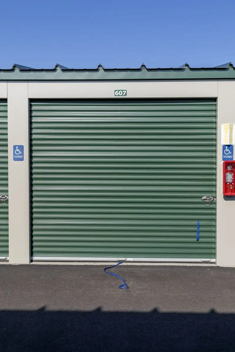 Accessible-marked drive-up storage unit with a green roll-up door