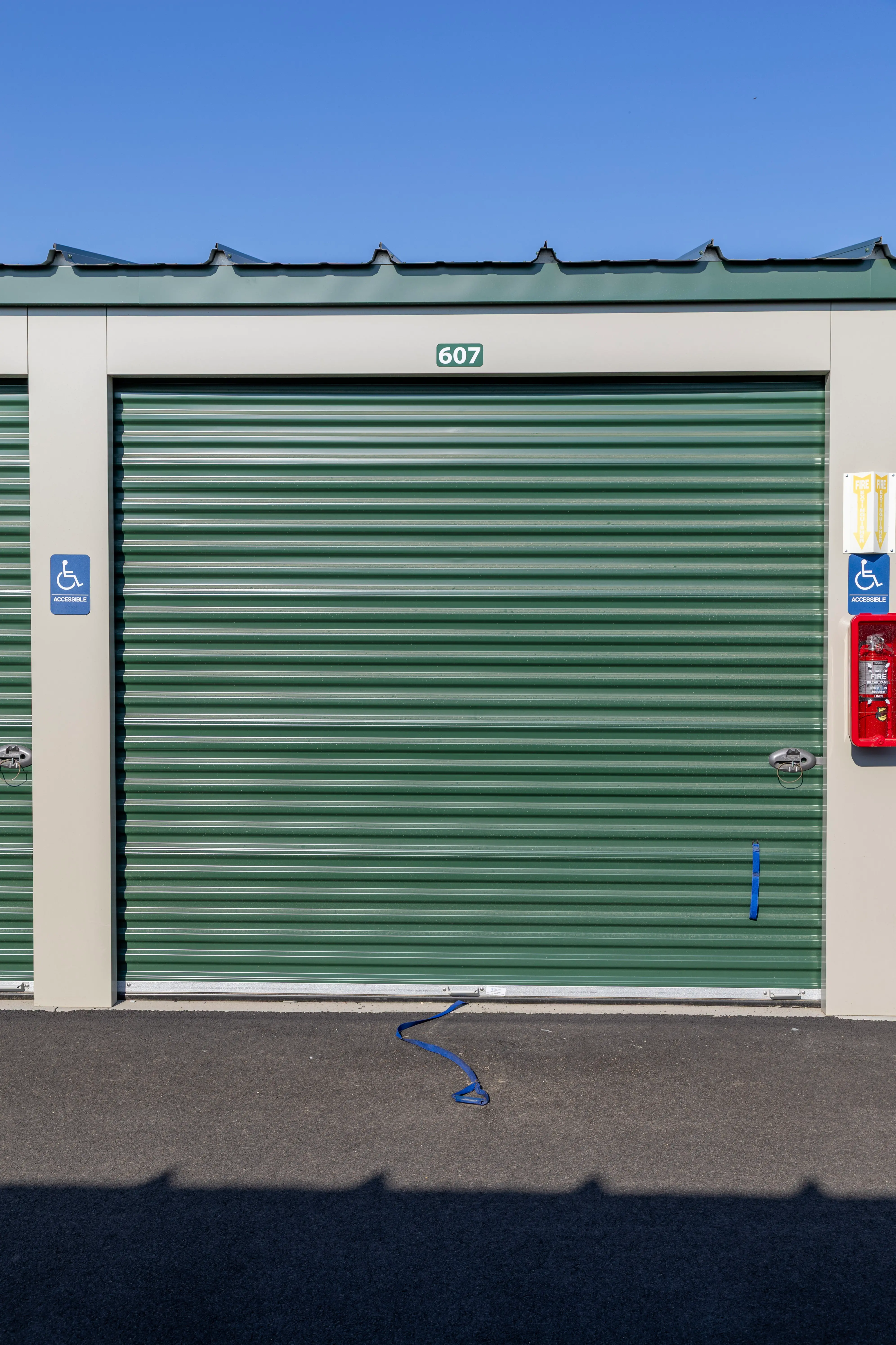 Accessible-marked drive-up storage unit with a green roll-up door