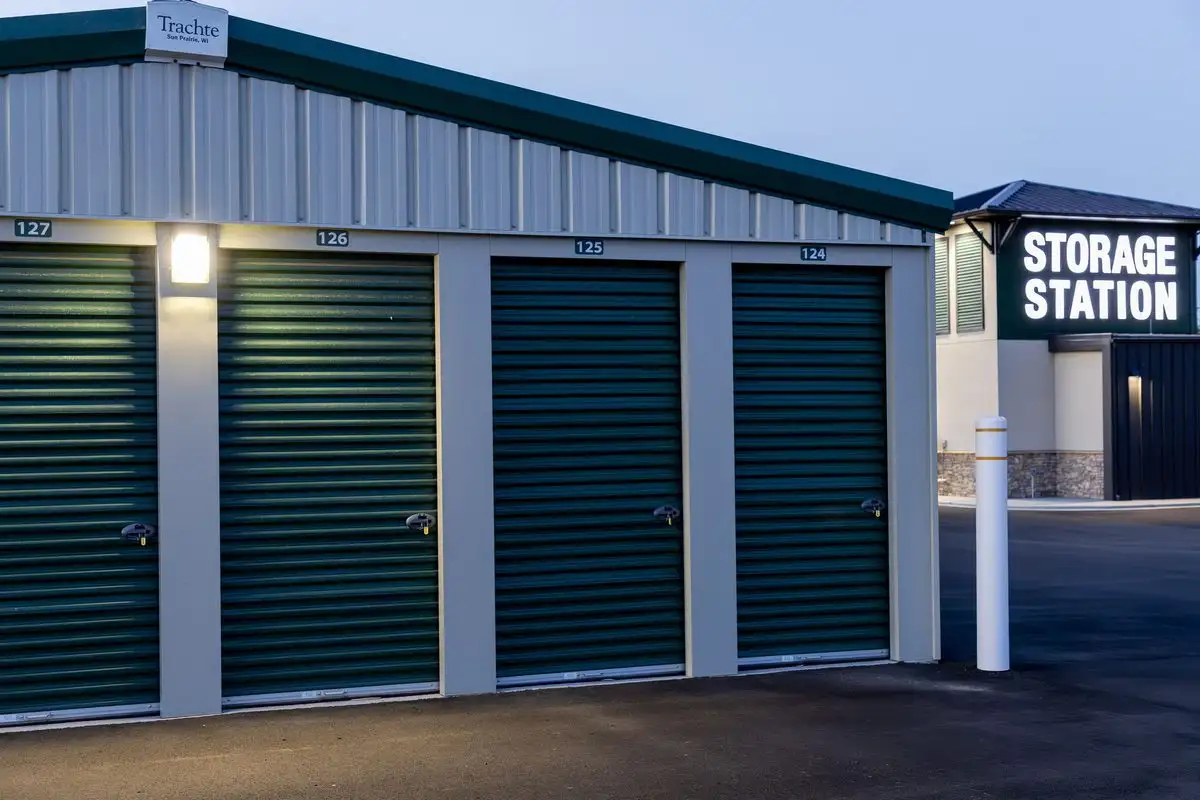 STORAGE STATION sign next to a row of drive-up units in evening light