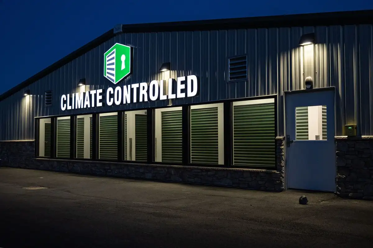 Wide row of drive-up storage units lit at sunset, columns of buildings extending into the distance