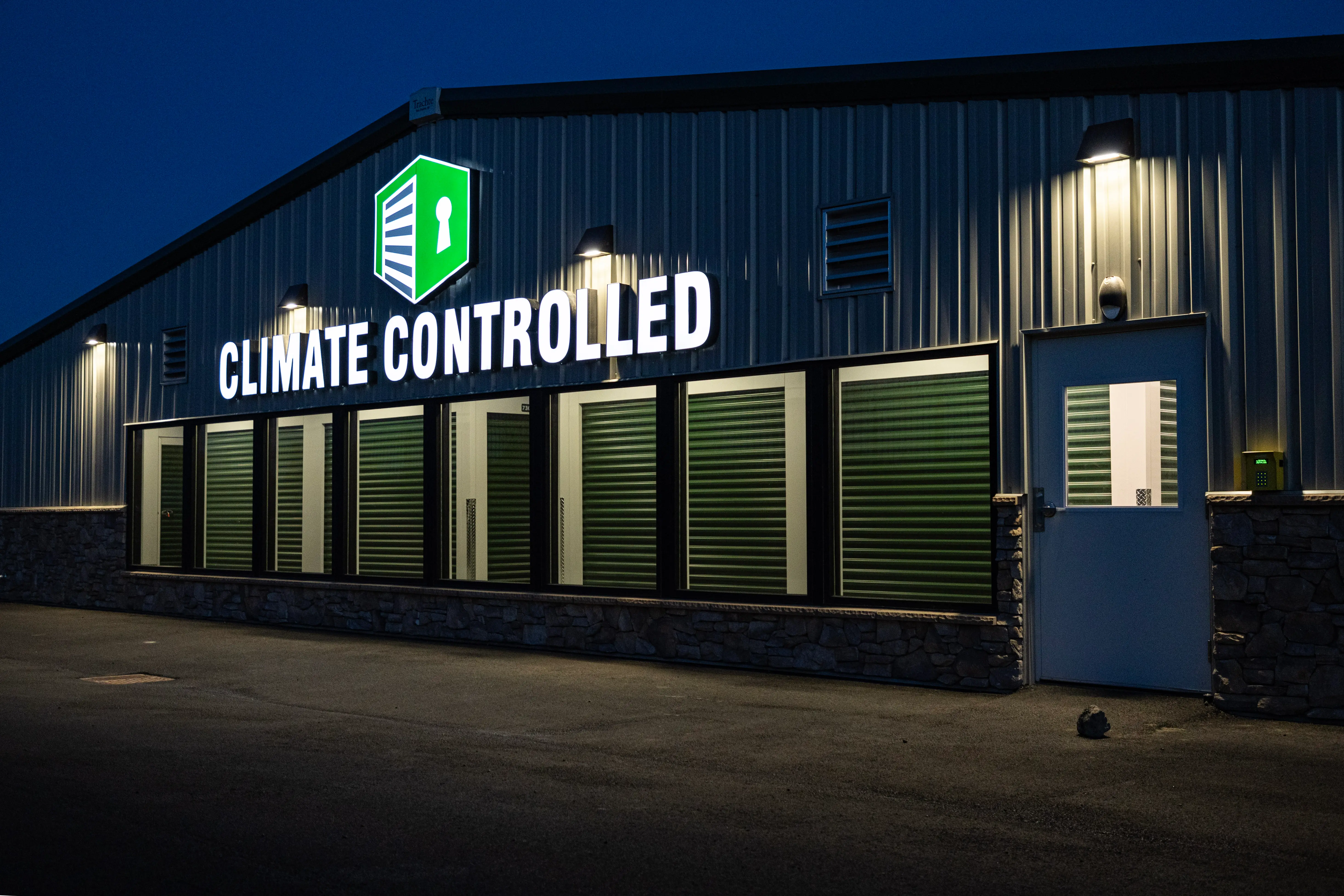 Wide row of drive-up storage units lit at sunset, columns of buildings extending into the distance